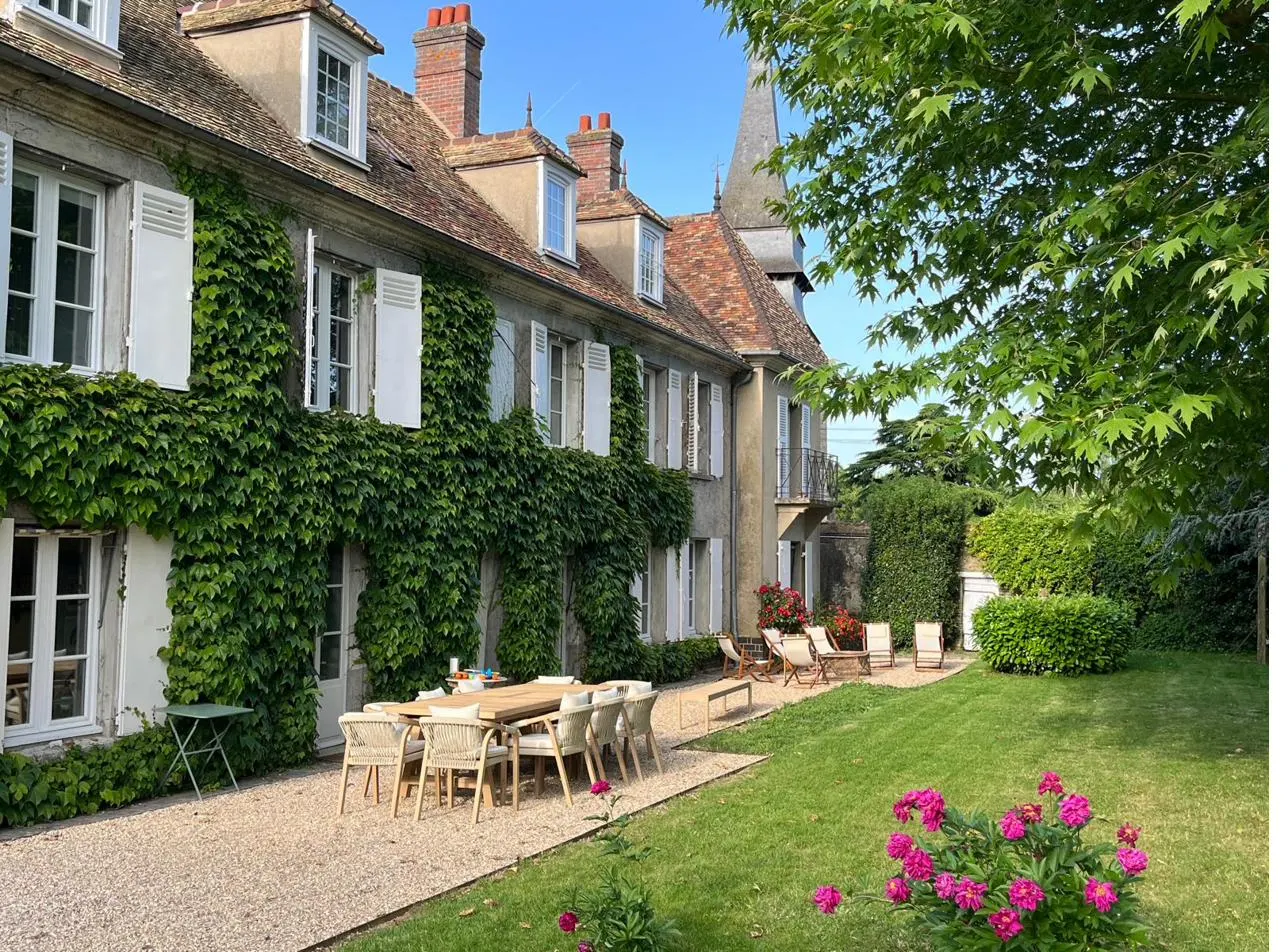 Table dressée au pied de la façade en vigne vierge — week-end de groupe au Prieuré Saint-Bû